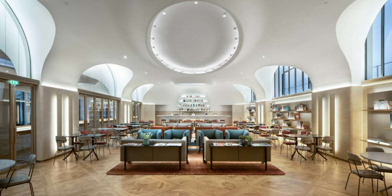 Grand salon voûté avec oculus lumineux central et bar sur mesure, bureaux Moët Hennessy conception lumière Ponctuelle