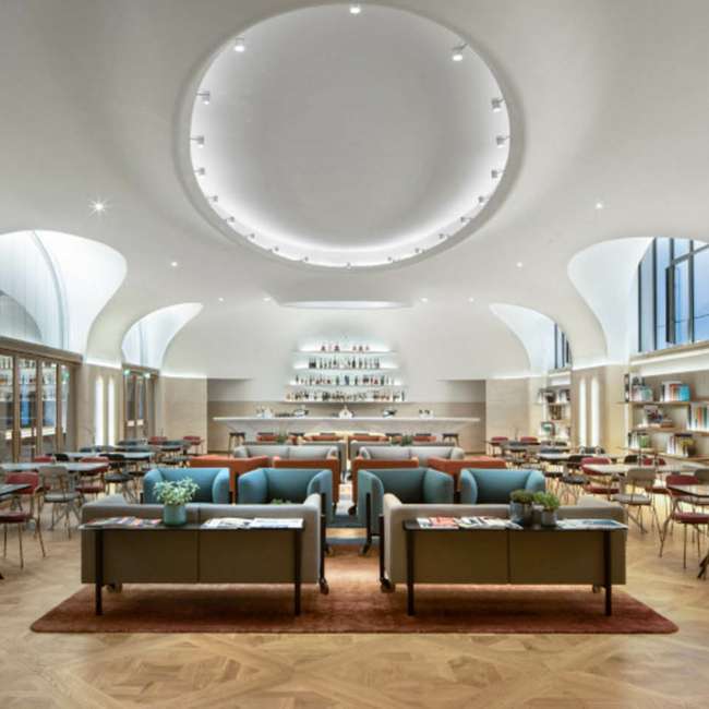 Large vaulted lounge with a central illuminated oculus and a bespoke bar, Moët Hennessy offices, lighting design by Ponctuelle