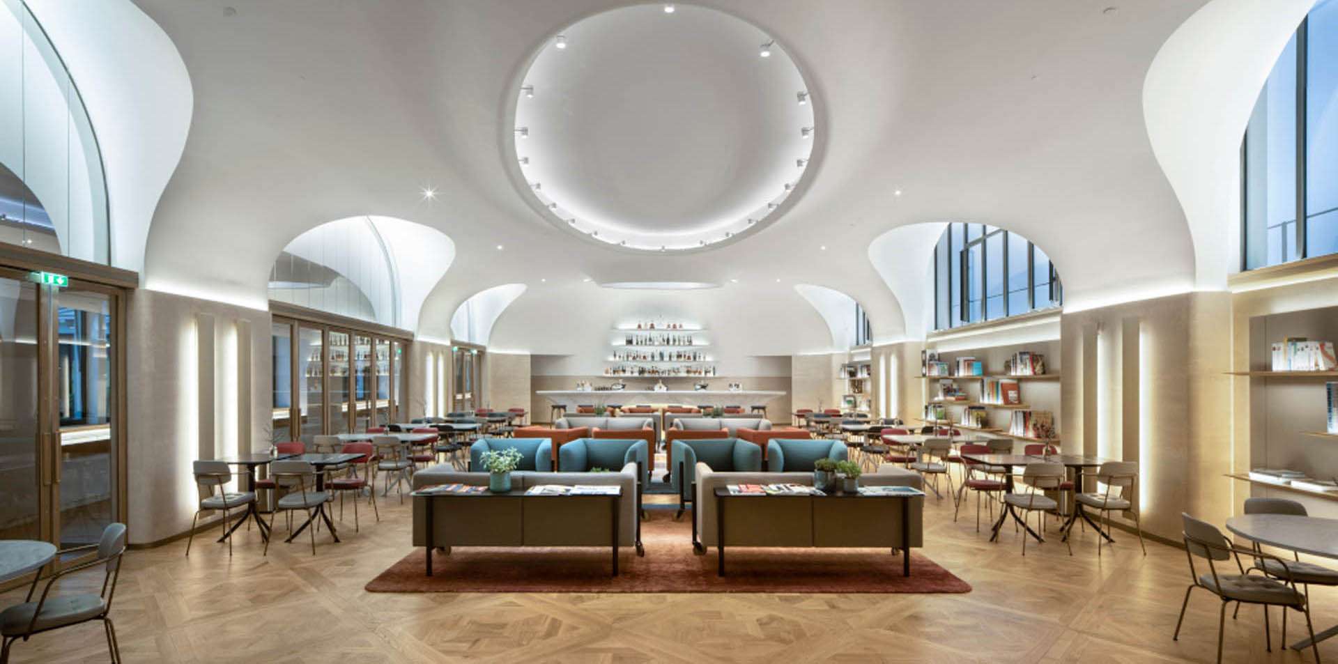 Grand salon voûté avec oculus lumineux central et bar sur mesure, bureaux Moët Hennessy conception lumière Ponctuelle