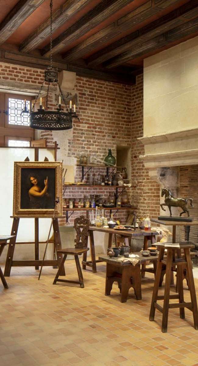 Vue large de l'atelier de peinture de Léonard de Vinci au Château du Clos Lucé avec cheminée monumentale, conception lumière Ponctuelle