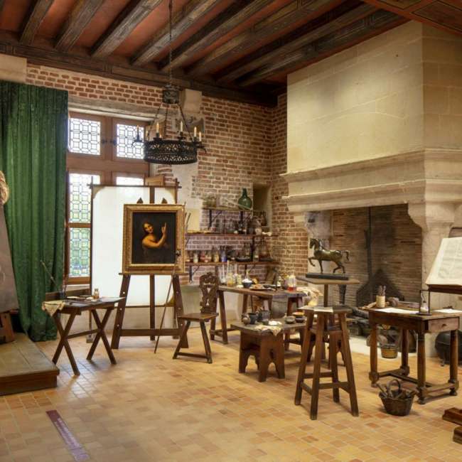 Vue large de l'atelier de peinture de Léonard de Vinci au Château du Clos Lucé avec cheminée monumentale, conception lumière Ponctuelle