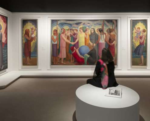 Salle d'exposition Art Déco France avec toiles figuratives éclairées et visiteuse assise, conception lumière Ponctuelle