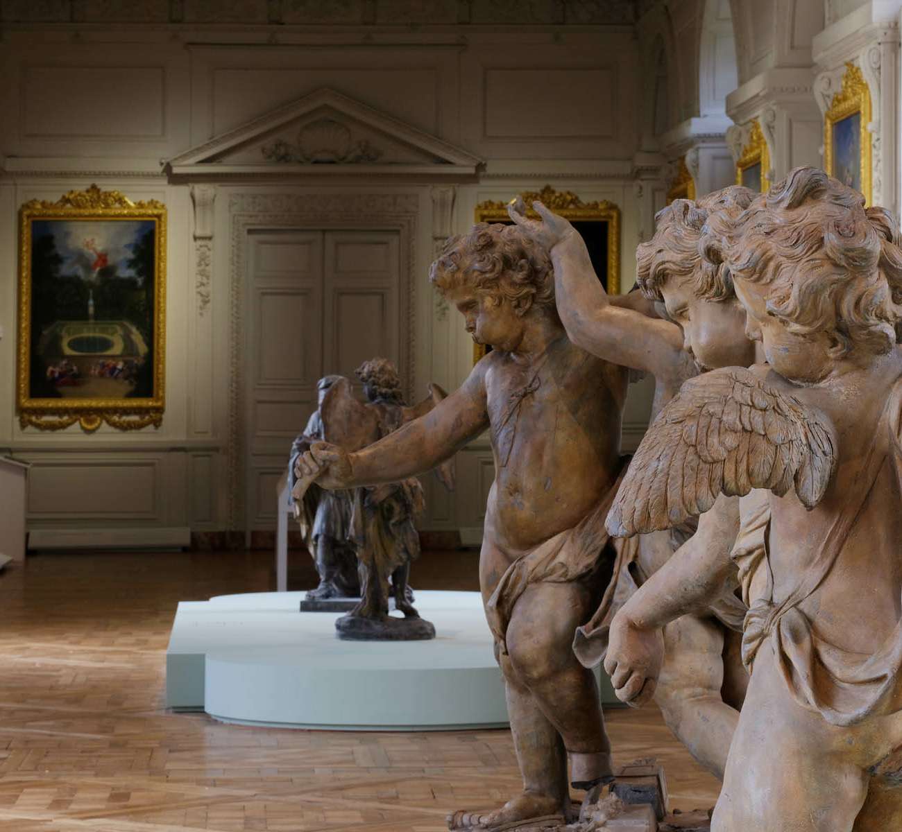 Groupe de sculptures de putti en terre cuite exposées dans la Galerie des Cotelles au Château de Versailles, conception lumière Ponctuelle