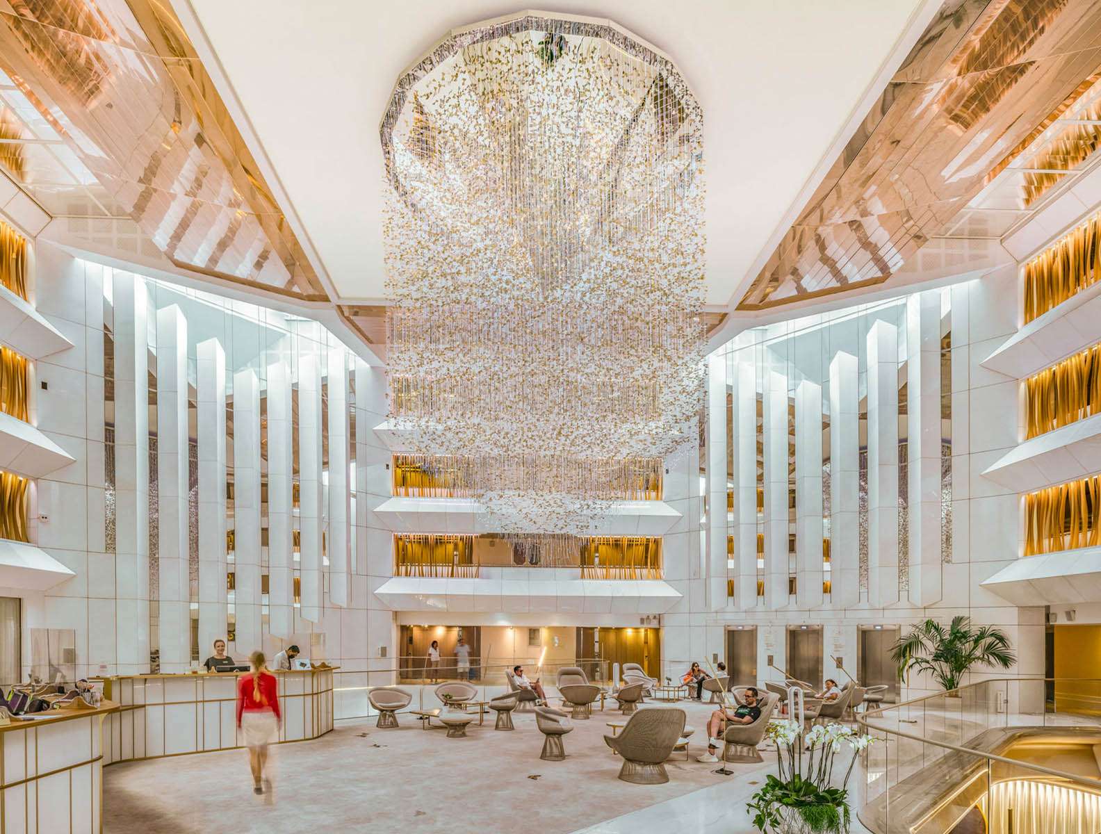 Hall de réception du JW Marriott Cannes avec suspension lumineuse monumentale et atrium sur plusieurs niveaux, conception lumière Ponctuelle