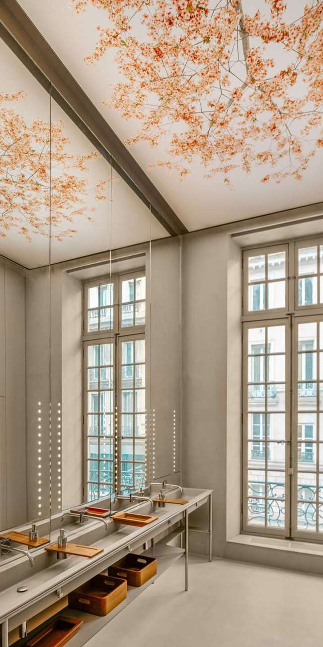 Sanitaires avec plafond illustré de fleurs de cerisier, éclairage vertical intégré L'Oréal Le Visionnaire