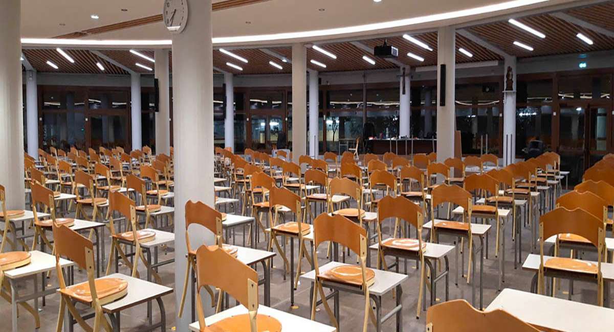 Éclairage architectural de la salle d’études du Collège Stanislas, rubans lumineux intégrés au plafond bois, conception lumière Ponctuelle