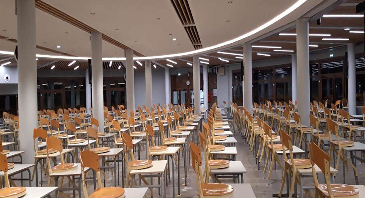 Éclairage architectural de la salle d’études du Collège Stanislas, rubans lumineux intégrés au plafond bois, conception lumière Ponctuelle
