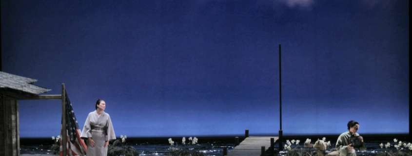 Madame Butterfly scene beneath a cloudy blue sky, Japanese house and timber jetty, Marseille Opera, lighting design by Ponctuelle
